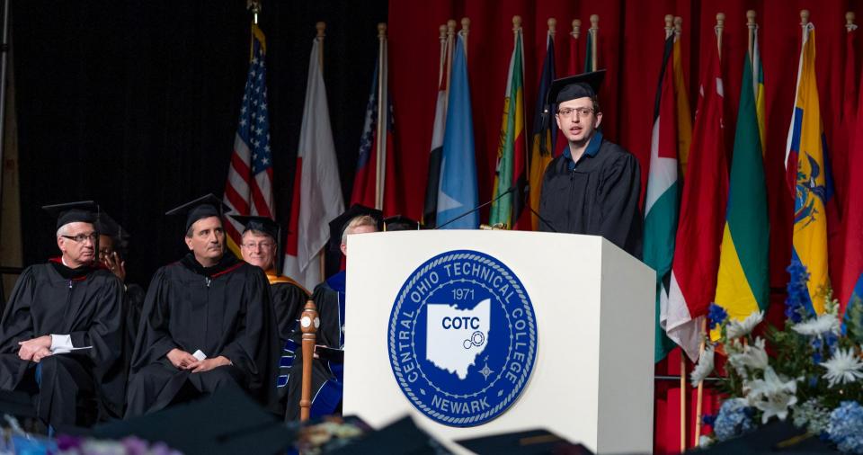 Jonny Lippincott stands  at a podium to deliver a speech during the commencement ceremony. 