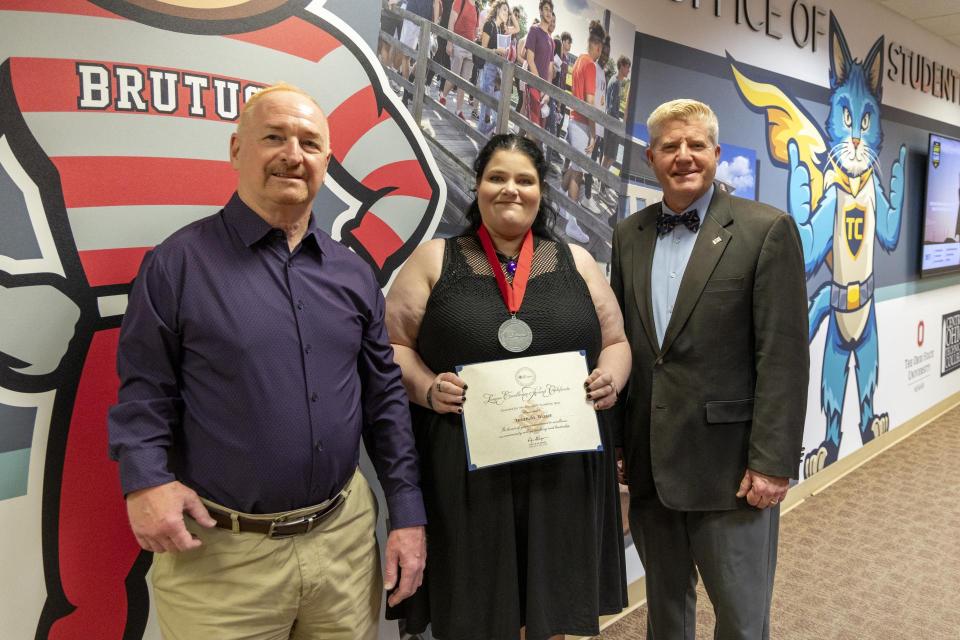 Provost Gregory Ferenchak, EdD; Amanda Waser; President John M. Berry, PhD Amanda Waser holds her League Excellence Award certificate while standing between COTC Provost Gregory Ferenchak and COTC President John Berry.