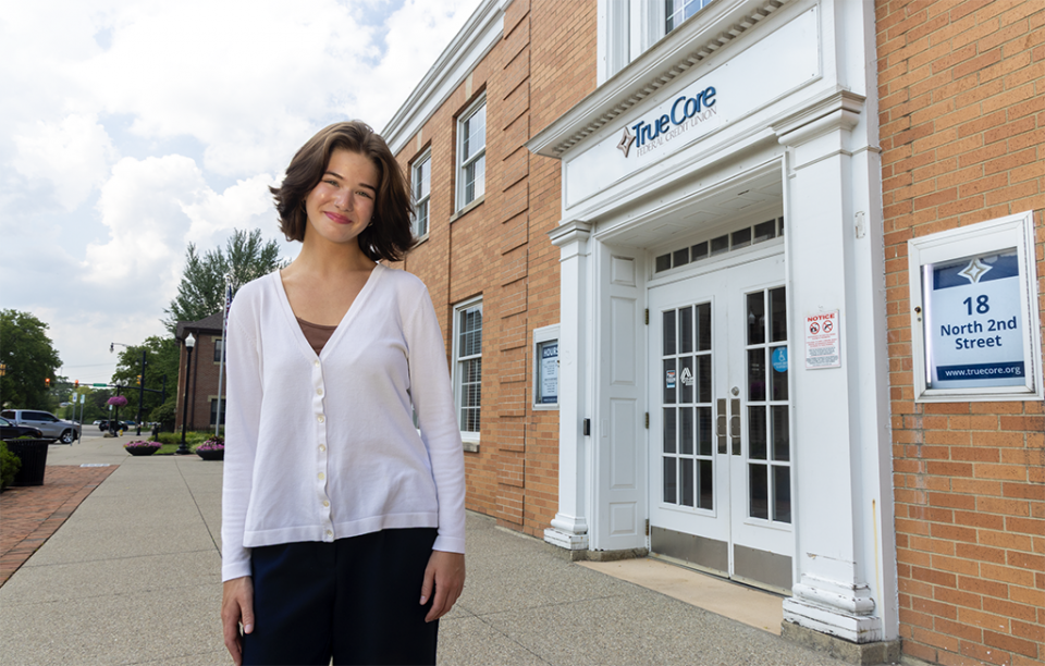 COTC alumna Sophia Tosi stands outside TrueCore Federal Credit Union where she works.