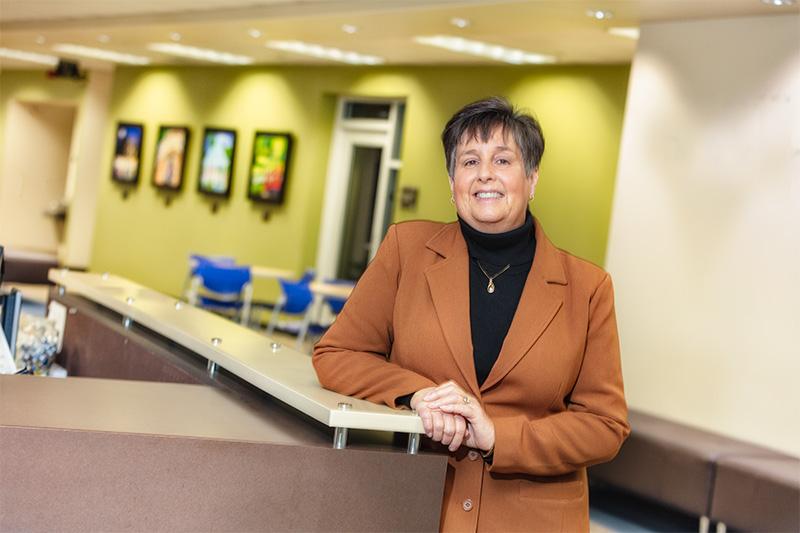 Vickie Sant sands in the COTC Knox campus lobby for a portrait.