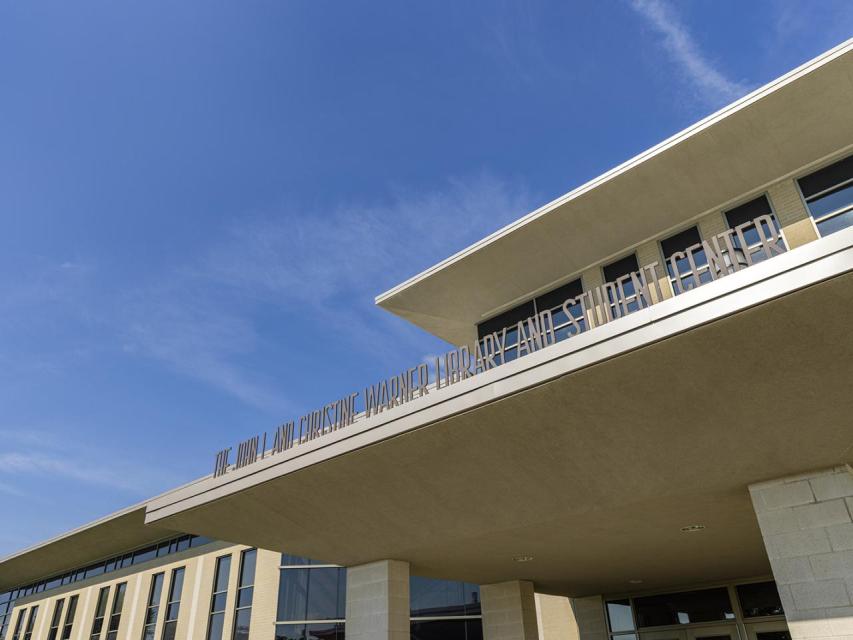 A close-up of the exterior of the Warner Center showing the name on the front side.