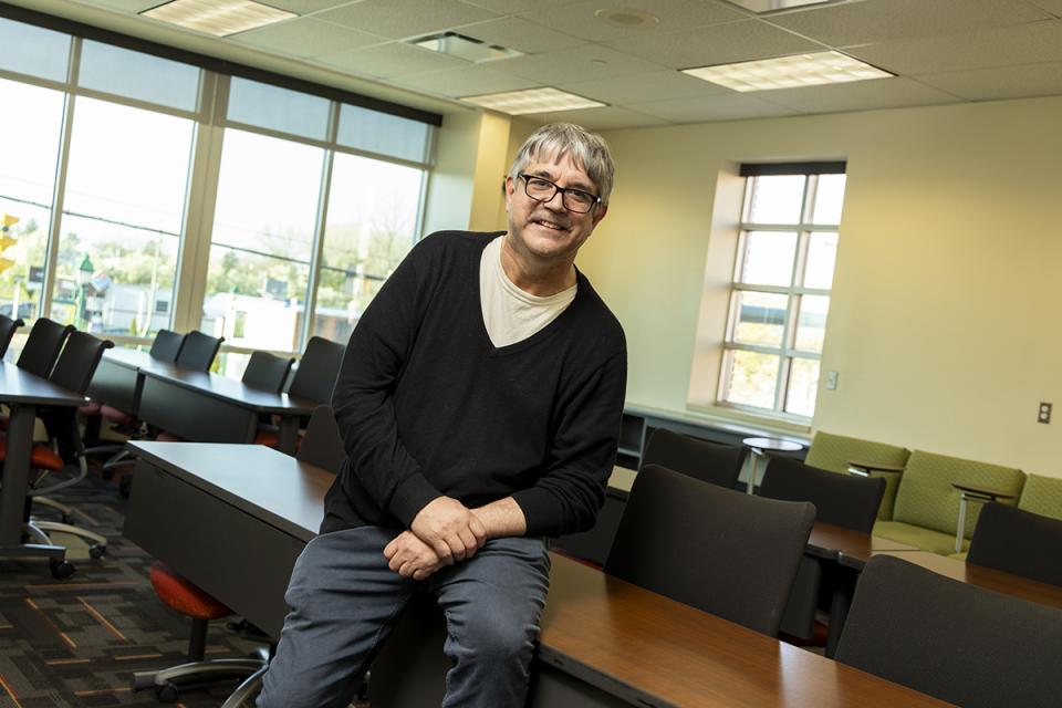 Portrait of Joe Hess in a classroom.